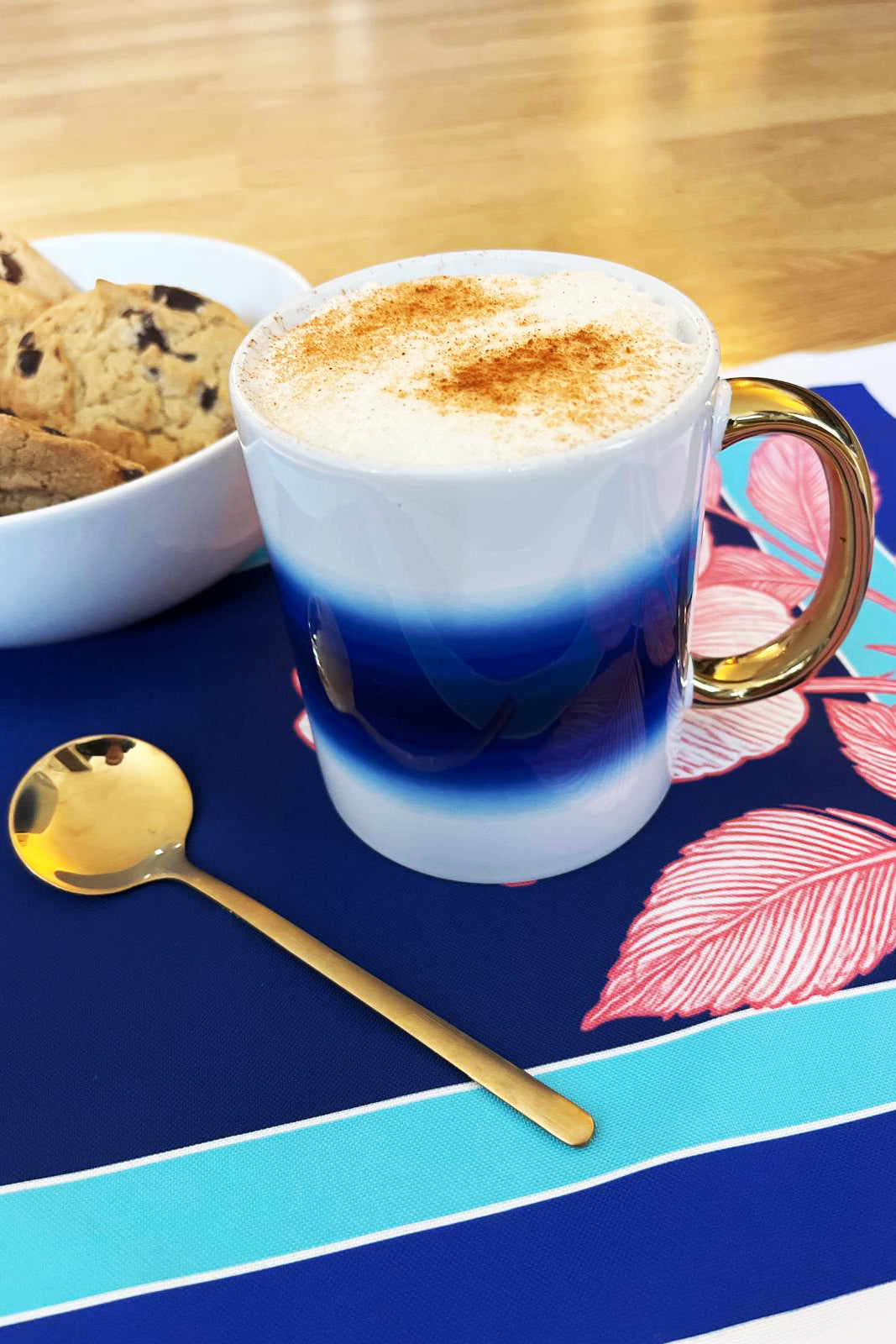 Cappuccino in a gradient mug with cookies and a spoon on a placemat. Exclusive design, designed in the UK, Count Me In Casa ceramic mug, Top quality 11oz ceramic Durham mug with gold handle