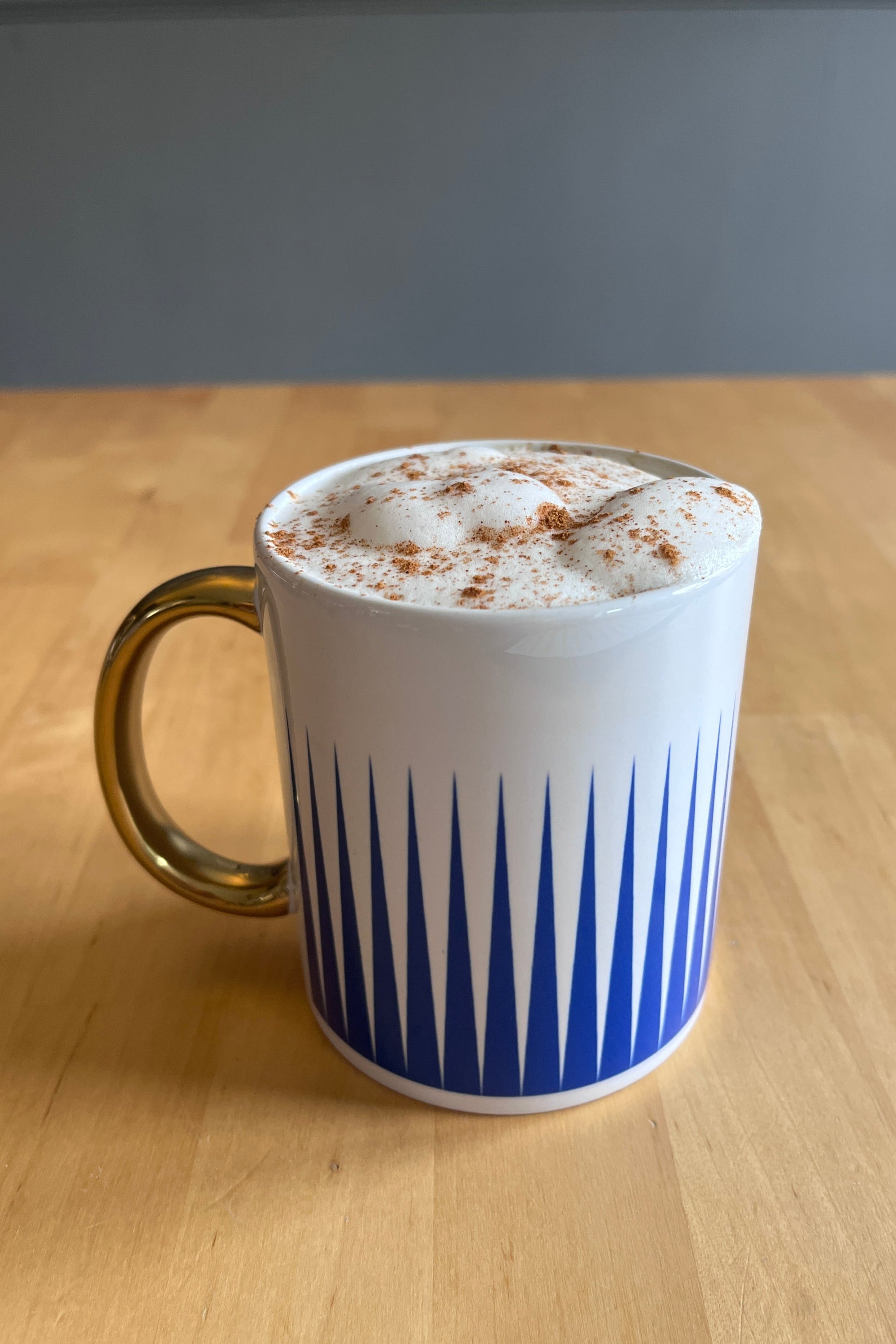 White mug with blue stripes on a wooden surface