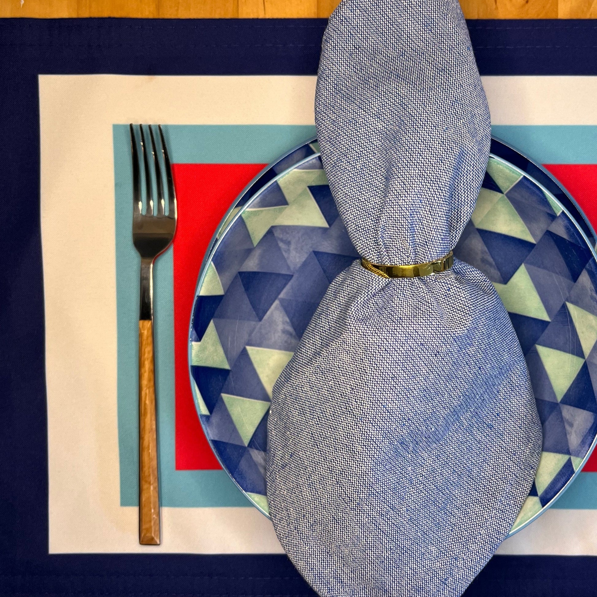 Plated setting with geometric plate, fork, and folded napkin on a patterned placemat.
