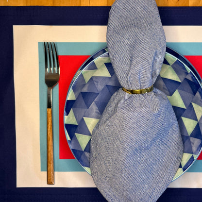 Plated setting with geometric plate, fork, and folded napkin on a patterned placemat.